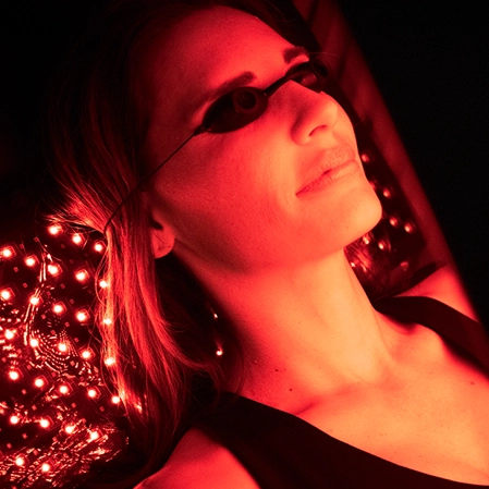 Chiropractic Madison AL Red Light Therapy On Face With Glasses